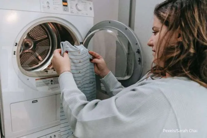 Mencuci baju di mesin cuci front loading