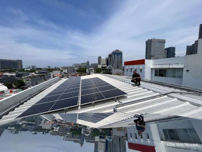 Petugas mengamat solar panel di atap gedung Auto 2000