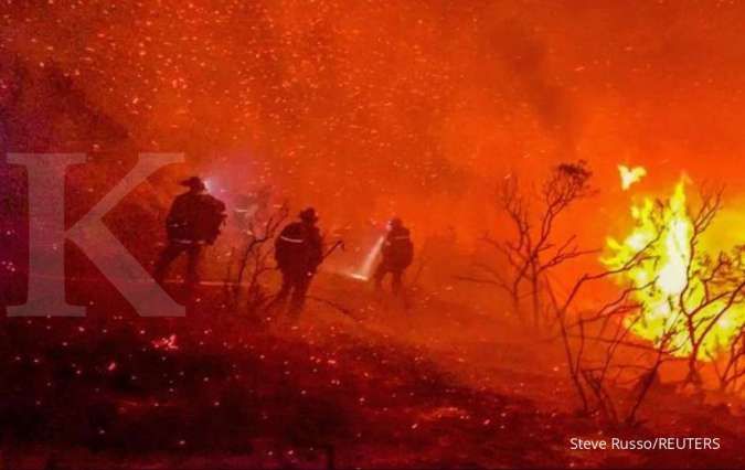 Petugas pemadam kebakaran terlihat berusaha memadamkan api yang menyala.