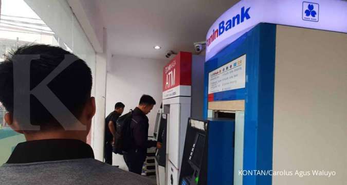 Warga menggunakan mesin anjungan tunai mandiri (ATM)