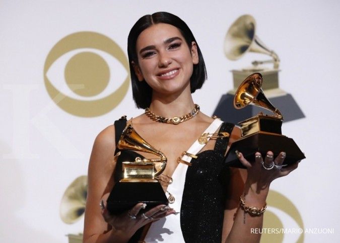 Dua Lipa berpose dengan penghargaan Grammy Awards yang diraihnya