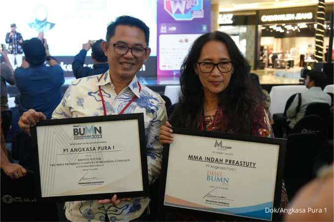 kiri-kanan - Vice President Customer Experience PT Angkasa Pura I Heru Nugroho dan Direktur Operasi MMA Indah Preastuty dengan plakat penghargaan.